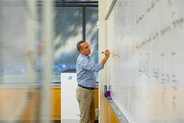 Professor writes on white board