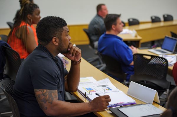 man takes notes in class