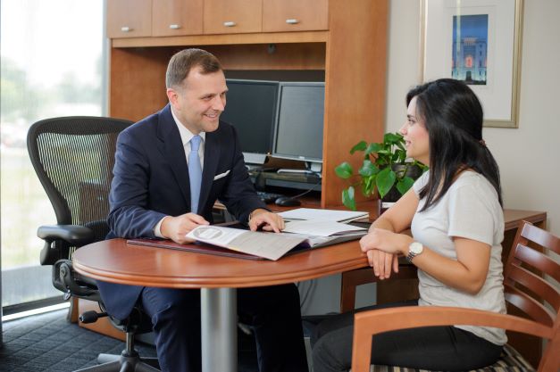 Male counselor meets with student at desk