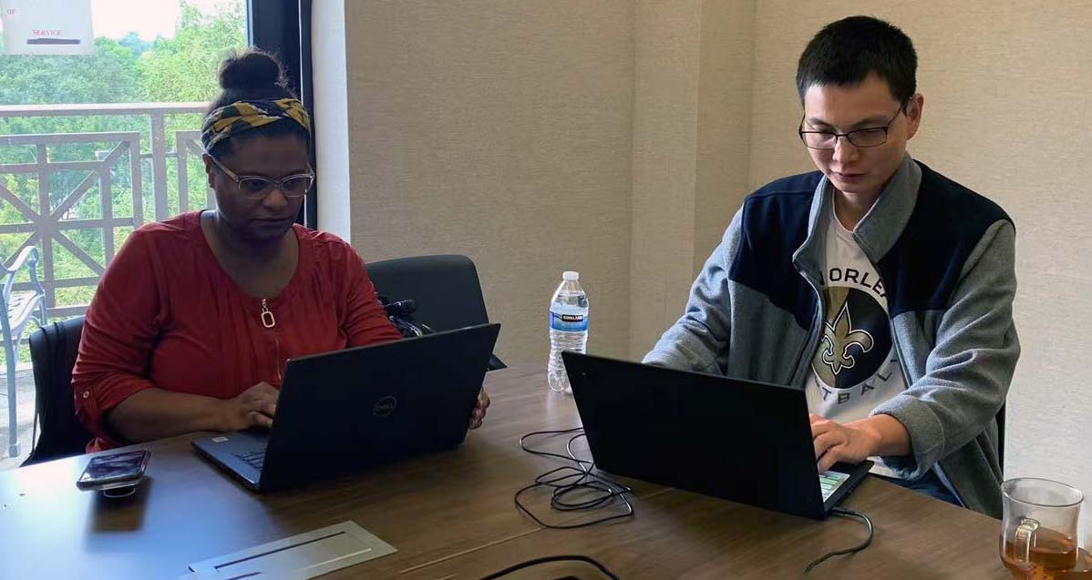 Two people sit at computers